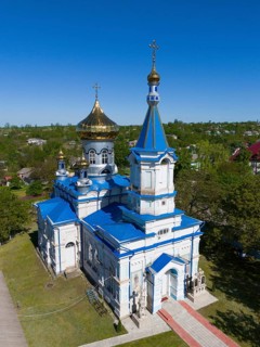Orthodox church with blue and gold dome in quiet surroundings, aerial view, Biserica de iarna,