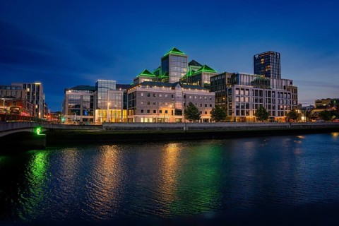 Modern urban skyline at night, reflecting lights on the river, Dublin, Ireland