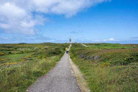 Hikers on a hiking trail on the Breton coast heading to Pointe du Raz with a view of the Sémaphore