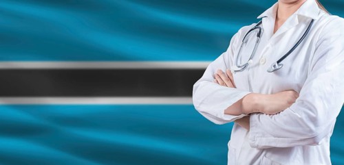 Doctor with crossed arms on Botswana flag. Botswanan health and care concept. Female doctor on