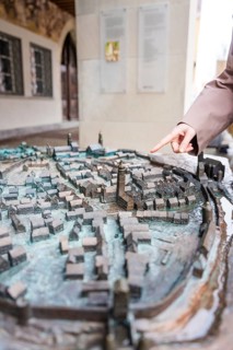 Hand points at a realistic miniature model of a city, Isny, Allgäu, Bavaria, Germany