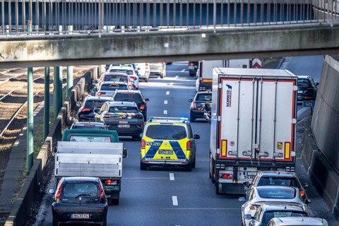 Traffic jam on the A40 motorway, emergency lane, vehicles on the left and right, police patrol car