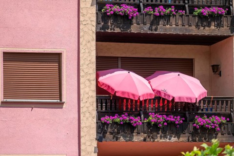 Residential building with pink façade, flowers and umbrellas, World Heritage Site Upper Middle