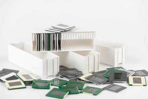 A mix of white and green slides surrounds white slide holders in a messy scene
