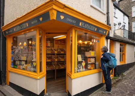 Tourist, elderly woman, looking at pastry, oat bars, pancakes, FLAPJACKERY shop, St Ives, Cornwall,