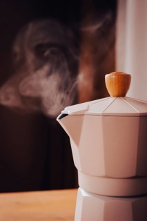 Geyser coffee maker, beige, close-up, boiling, steam from the spout, morning, breakfast, no people