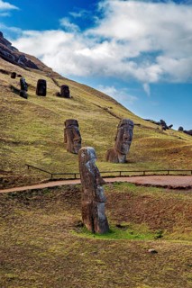 Several Moai statues on a green hill with a blue sky full of clouds, The Moai statues on Easter