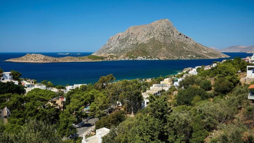 Massouri, panorama of a quiet bay with coastal villages and lush greenery in front of steep