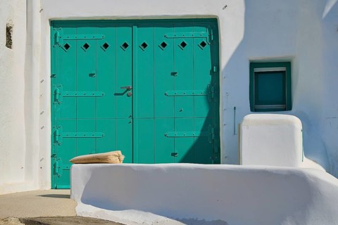 Close-up of a large green door at a white minimalist house with Mediterranean flair, Syrmata, boat
