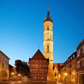 Old scales, detailed reconstruction with the illuminated St Andrew's Church in the evening,
