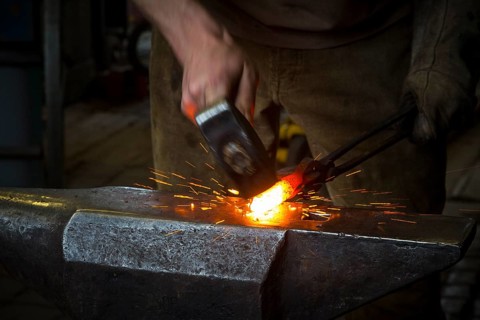 Sparks spray, a blacksmith forging, working at the Ehnert forge in Dresden-Bühlau, Saxony, Germany
