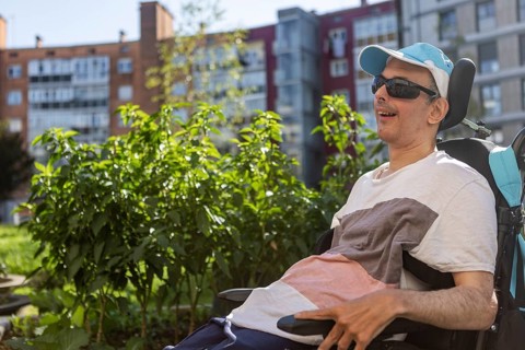 Person enjoying the outdoors in a day center setting, highlighting inclusion and support for