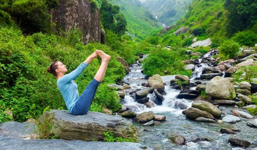 Yoga exercise outdoors, panorama of woman doing Ashtanga Vinyasa Yoga balance asana Ubhaya