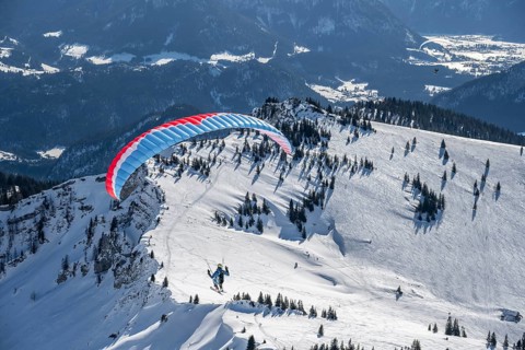 Mountains in winter, paraglider with skis on Sonntagshorn, Chiemgau Alps, Bavaria, Germany