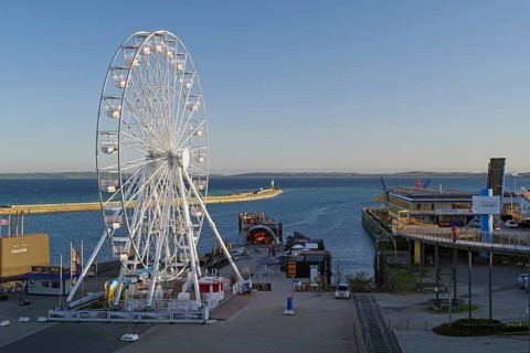 Ferris wheel in harbor with sea view and parked ships, Sassnitz, Rügen, Mecklenburg-Western