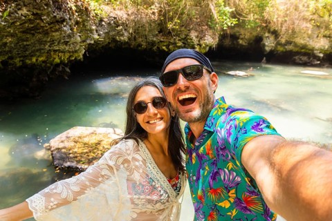 Portrait selfie couple man woman travelers wear vibrant tropical shirt takes pose in Baraka Natural