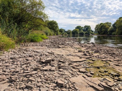 Rocky river landscape, dry rock slabs and algae growth, riverbank, Altocumulus, Stratocumulus,