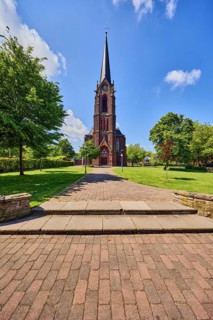St. Nicholas parish church, church tower, sandstone wall, staircase, green area Bürgerpark, lawn,
