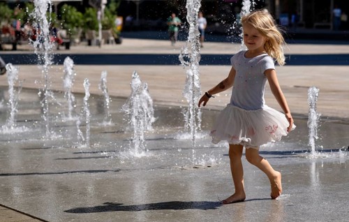 Girl, 4 years, blonde, playing barefoot with water, water playground, fountain field, market