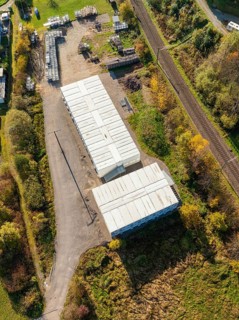 Aerial view of an industrial complex with railway tracks and vegetation, refugee accommodation