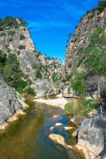 Crystal clear canaletes river meandering through a picturesque gorge at the fontcalda sanctuary, a