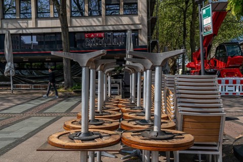 Stacked chairs and tables from various catering establishments, on Kennedyplatz, closed cafes,