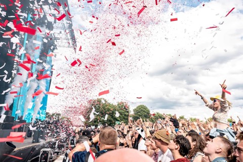 Rain of confetti at Finch's performance, festival goers sit on the shoulders of other festival