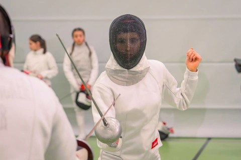 A person wearing fencing clothes concentrates during a training battle in the hall, fencing, TSV