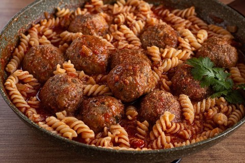 Minced meat meatballs, in tomato sauce, with fusilli pasta, in a cast-iron pan, homemade, no people