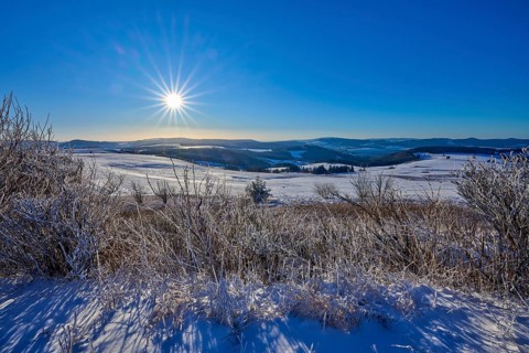Landscape with bright sun and snow-covered hills, winter, Wasserkuppe, Gersfeld, Rhön, Hesse,
