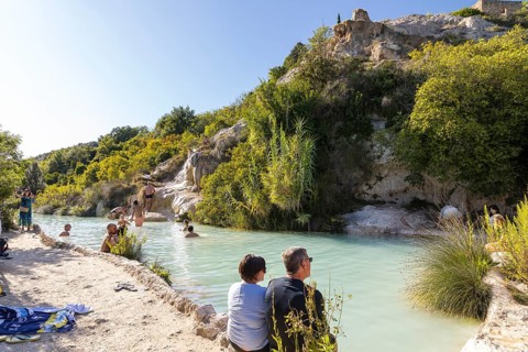 Bathers in one of the thermal pools between the cascades in the limestone on the steep slope of the