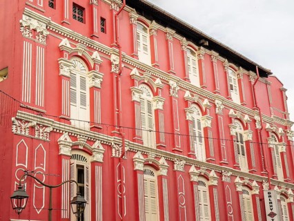 Intricate architectural details of a heritage building with a striking red facade, located in