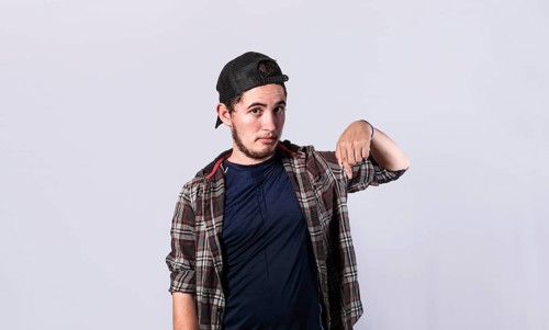 Friendly bearded man pointing down on isolated background, friendly guy pointing down and