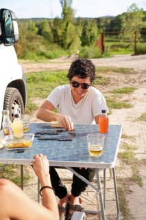 A lesbian couple enjoys a carefree afternoon playing games by their motorhome in a picturesque