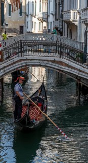 Gondolier on a Venetian gondola on the Rio di Palazzo canal, Venice, Veneto, Italy