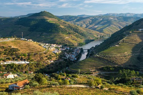 Regua town in Douro Valley Portugal, with winding Douro river, vineyard hills, mountain layers and