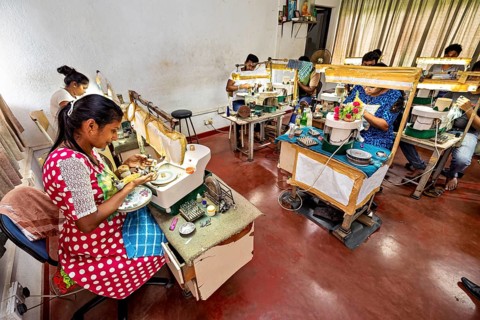 A room full of people concentrating on pieces of jewelry in an educational atmosphere, The sapphire