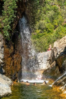 Men and woman bathing in the natural rock pools and waterfalls of Charco del Canalon, Rio Verde