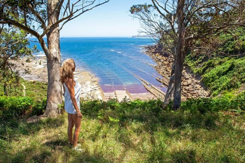 Middle aged woman looking at the landscape in Liñera point cove in western Cantabria, a region of