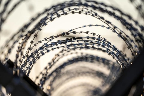 Symbolic image security, S-wire rolls, NATO wire, on a fence top, demarcation of a property,
