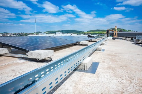 Solar panels on a roof with a view of landscape and blue sky, industrial environment, PV