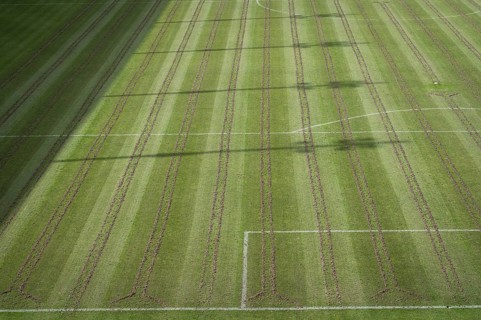Soccer pitch with pices of soil after aeration maintance