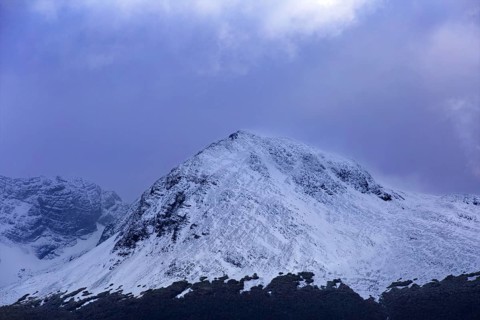 Single snow-covered mountain peak under a shady sky in Ushuaia, Ushuaia, Argentina