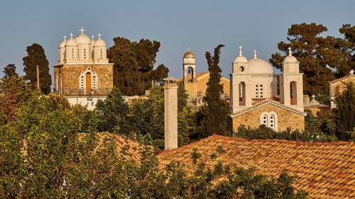 Church architecture with domes and towers against a background of trees in the evening light,