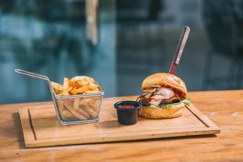 Delicious big burger with fries served on a restaurant table