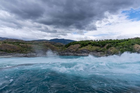 Confluence of Río Baker and Río Neff, turquoise blue water with rapids and spray, cloudy sky over