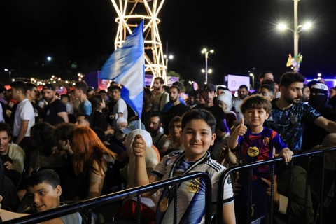 Damascus, Syria - July 19, 2026: A young boy waves the Argentine national flag high amidst