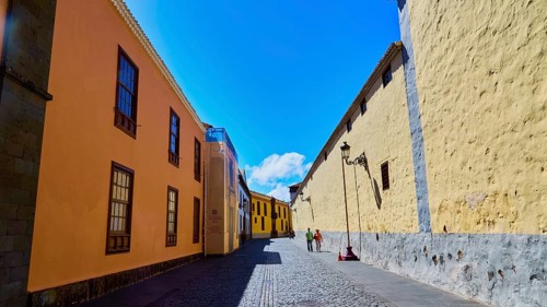 A sunny alley with yellow historic buildings under a clear blue sky, UNESCO World Heritage Site,