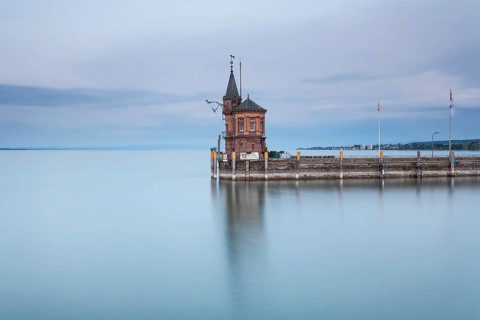 Long exposure of the historic gauge house at the harbor entrance on the smooth water surface of