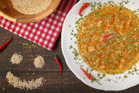 Decorated soup plate next to a smiling quinoa face on rustic table